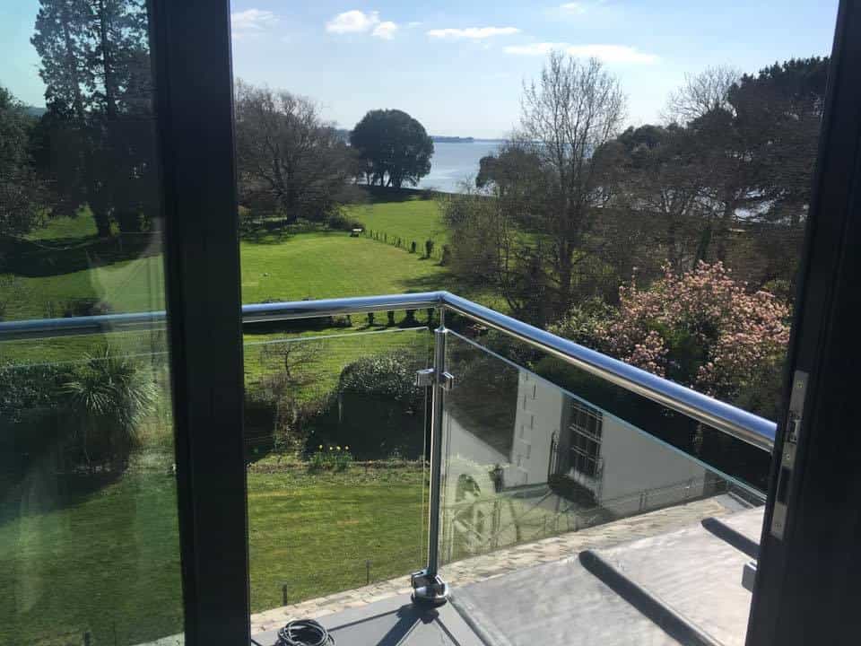 glass balcony overlooking a large garden